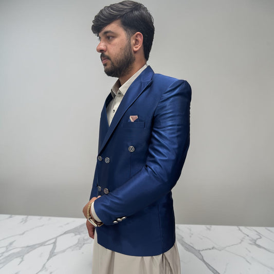 Man wearing a blue blazer over a white shirt on a gray background